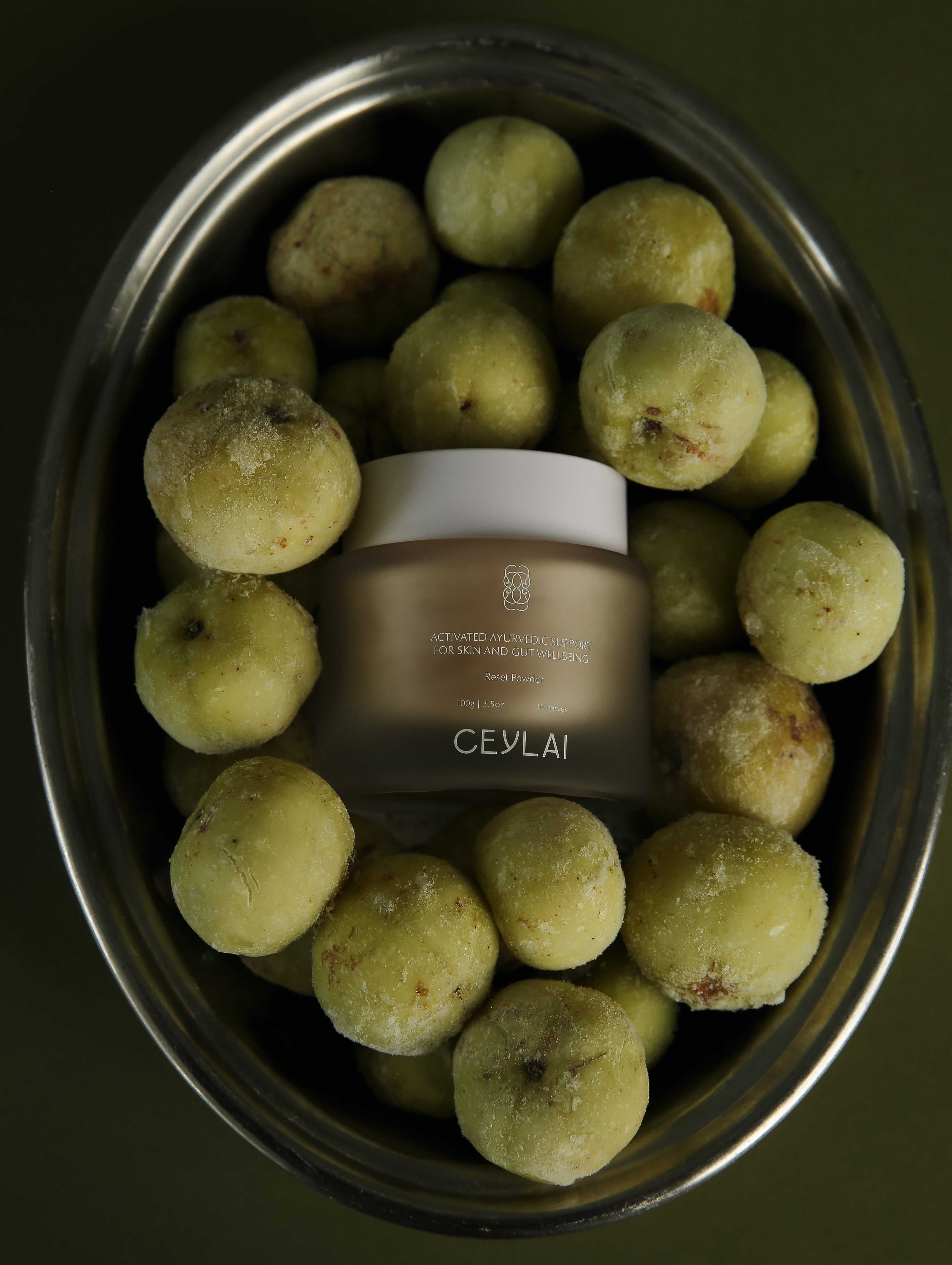 Ceylai skincare product surrounded by green fruits on a dark background