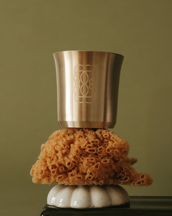 Bronze cup on a sea sponge with a green background.
A handcrafted Kansa vessel for daily nourishment and ritual.
The CEYLAI Kansa Ritual Cup is crafted from pure Kansa, a traditional bronze alloy long used in Ayurvedic living. Handcrafted by artisans, each cup carries subtle variations in tone and texture, reflecting the beauty of a material shaped slowly, with care and intention. Designed to be used with the CEYLAI Reset Powder, the cup transforms a simple drink into a moment of ritual.
